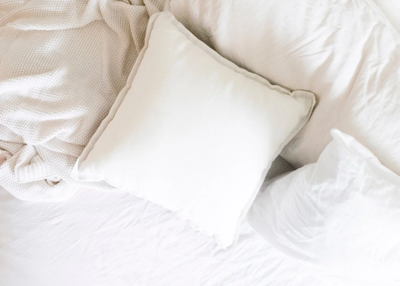 A white pillow resting on a neatly made bed, a quiet picture of comfort and personal space in intimate relationships.