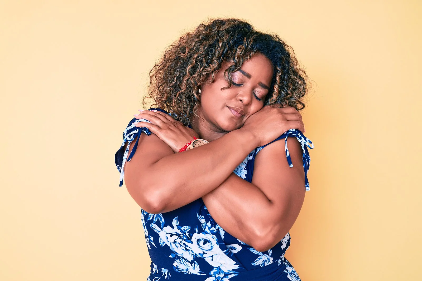 A woman embracing herself, a picture of self-love and confidence after a breakup.