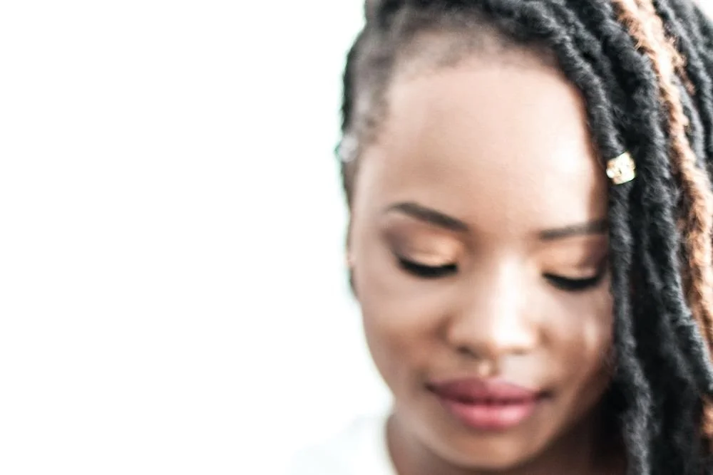 A close-up of a woman with braided hair looking down calmly, a moment of stillness after anxiety.Terri Cole quote graphic: "Your job as a grown up is to set the boundaries that work for you in your adult life."