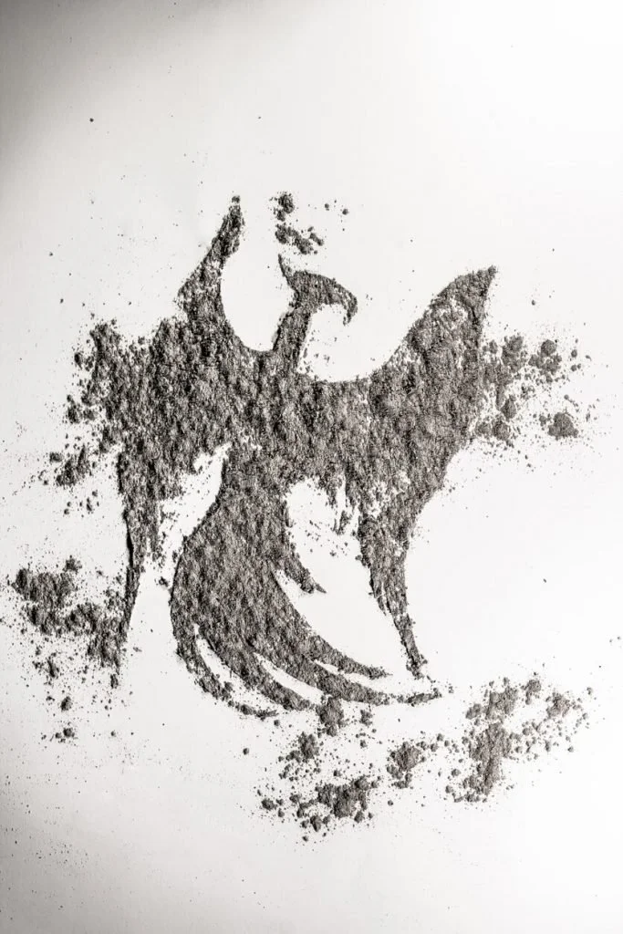 Gray ashes on a dark background, a symbol of the end that comes before a new beginning.