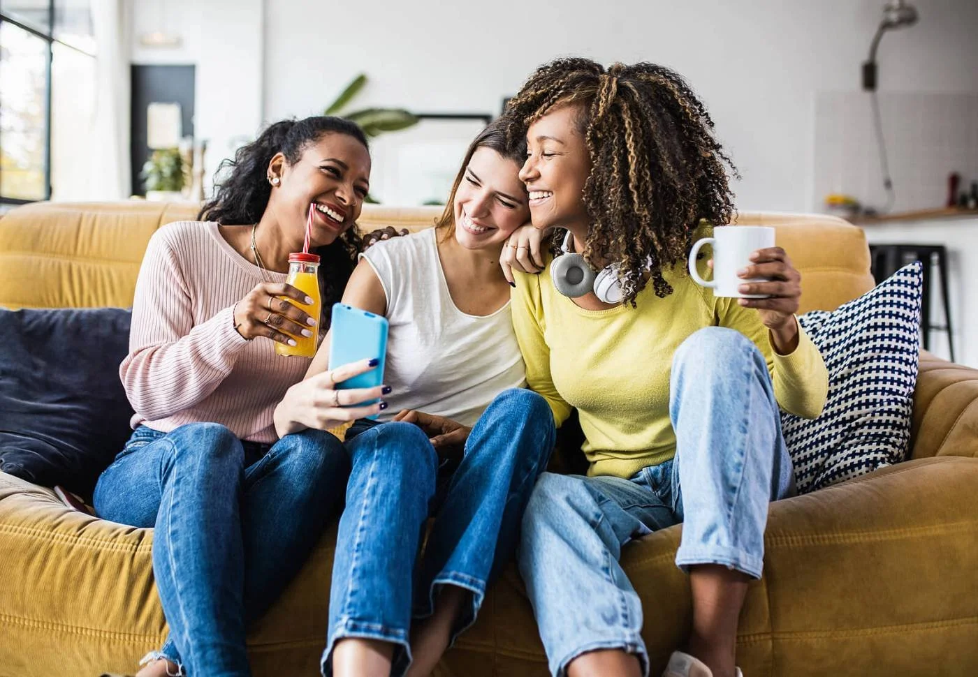 Friends laughing together on a couch, the kind of easy time with people that feels good to an introverted woman.