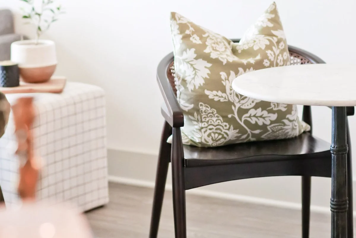 A cozy chair with a pillow beside a small table, a quiet spot to take the break that healthy professional boundaries allow.