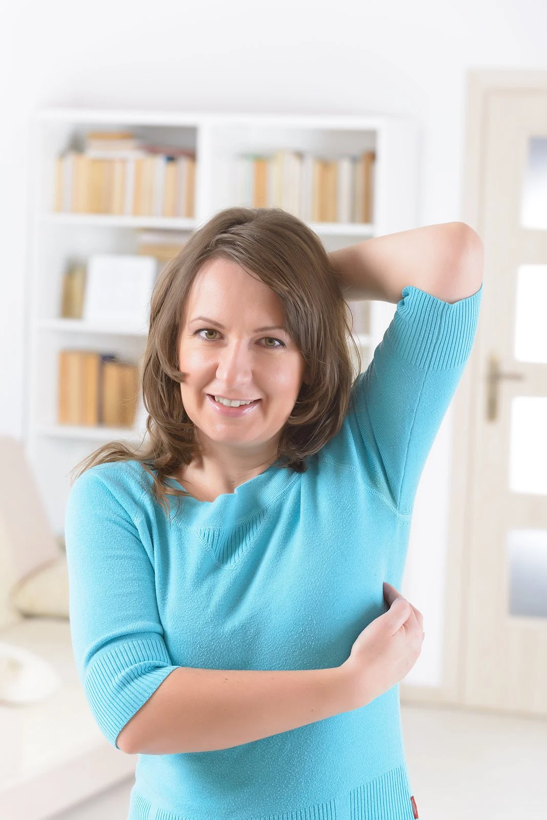 A woman smiling and tapping her underarm point during EFT, a gentle way to move through strong emotions and tears.