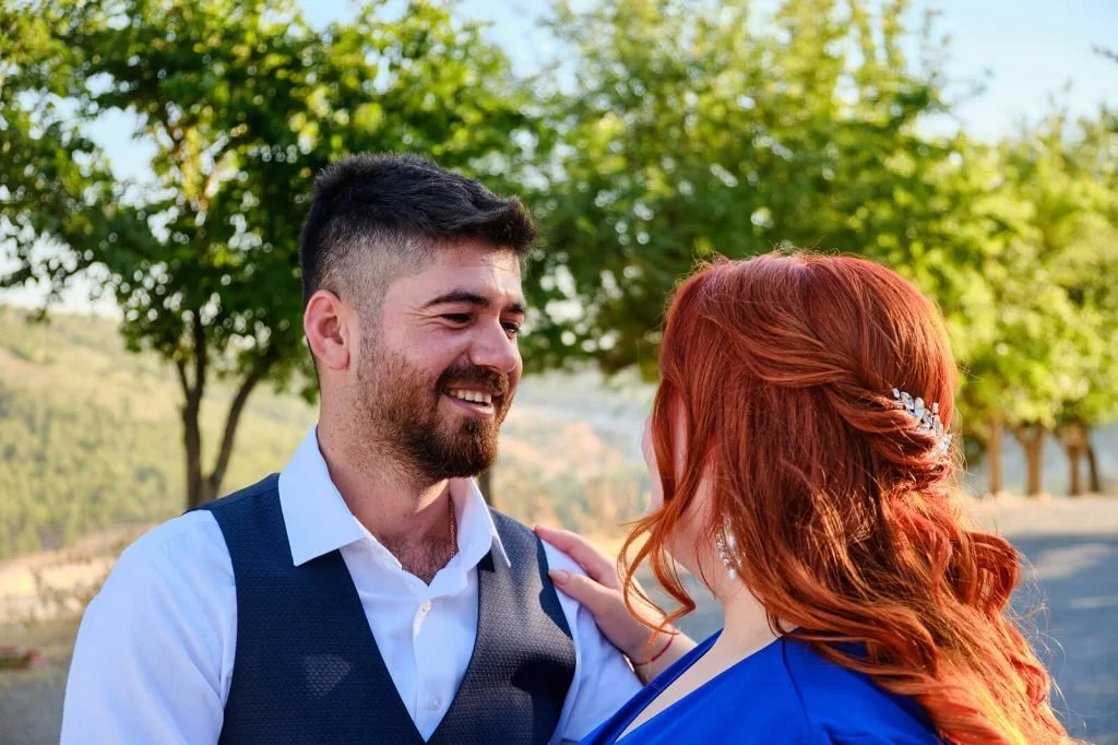 A couple smiling at each other, enjoying a relaxed date.