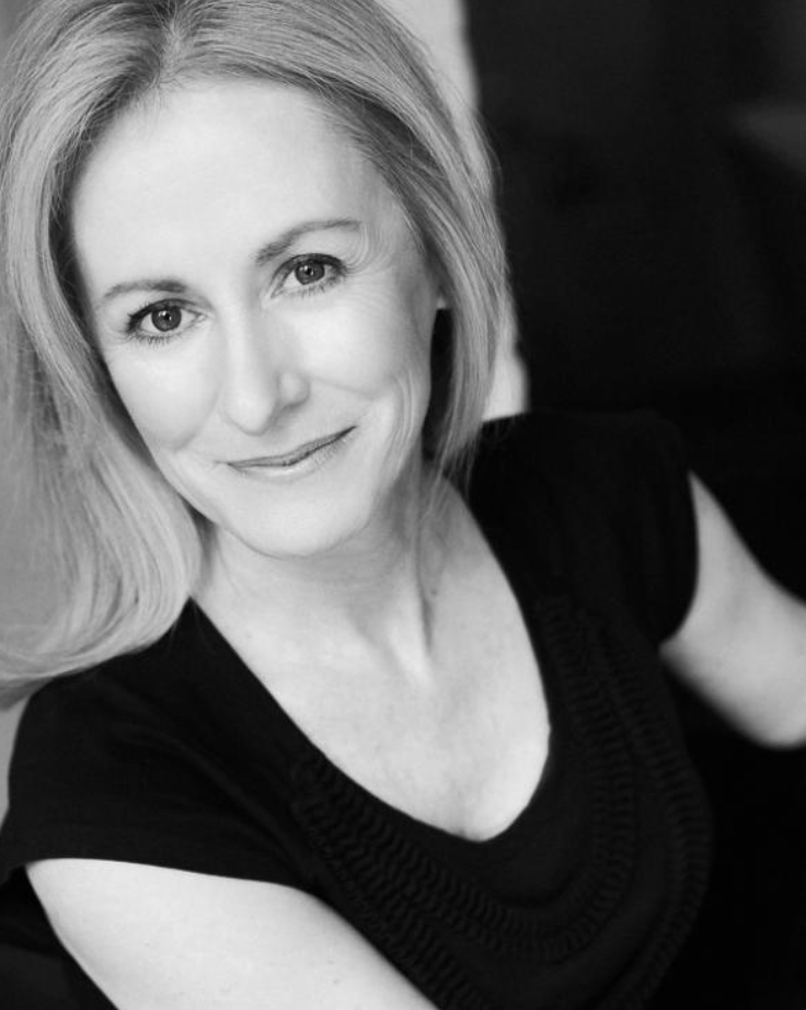 A woman with shoulder-length blonde hair and a slight smile, wearing a black top, looking at the camera in a close-up portrait. Shannon Holt On The Rocks Theatre Edelweiss