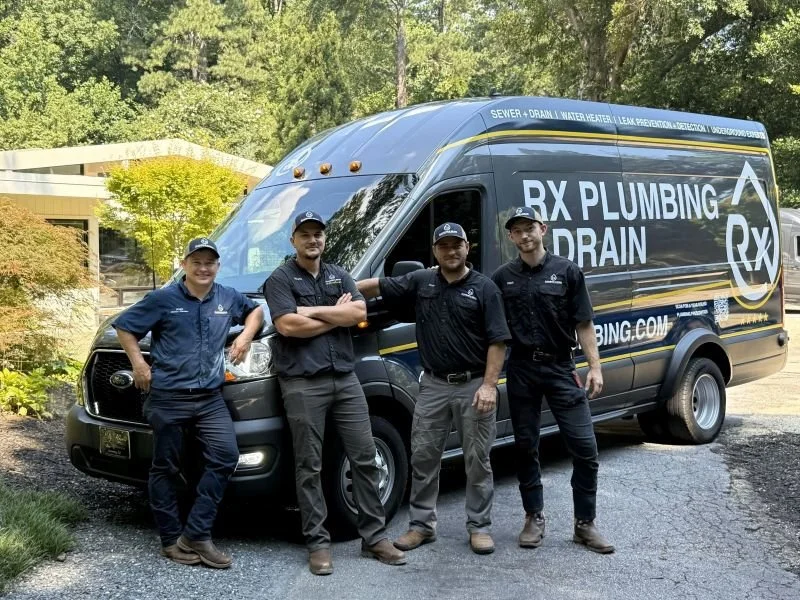 The Rx Plumbing team stands next to an Rx emergency response van at a home project in Alpharetta, GA.
