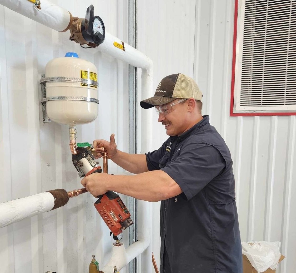 Rx-Plumbing and Drain Master Plumber working on copper pipe with a Ridgid tool.