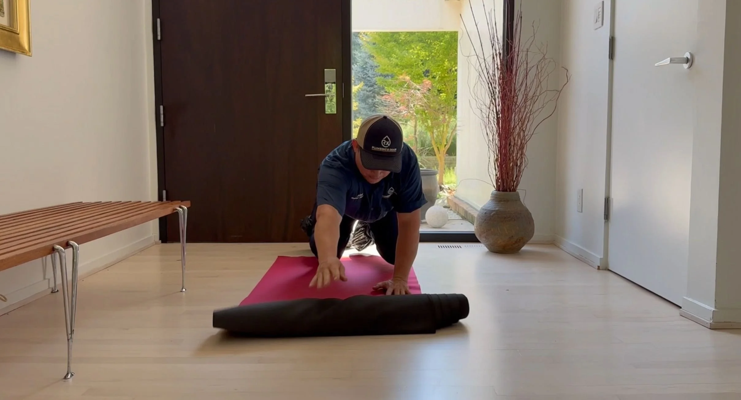 Rx-Plumbing and Drain plumber laying down a protective mat to keep the space clean before beginning work.