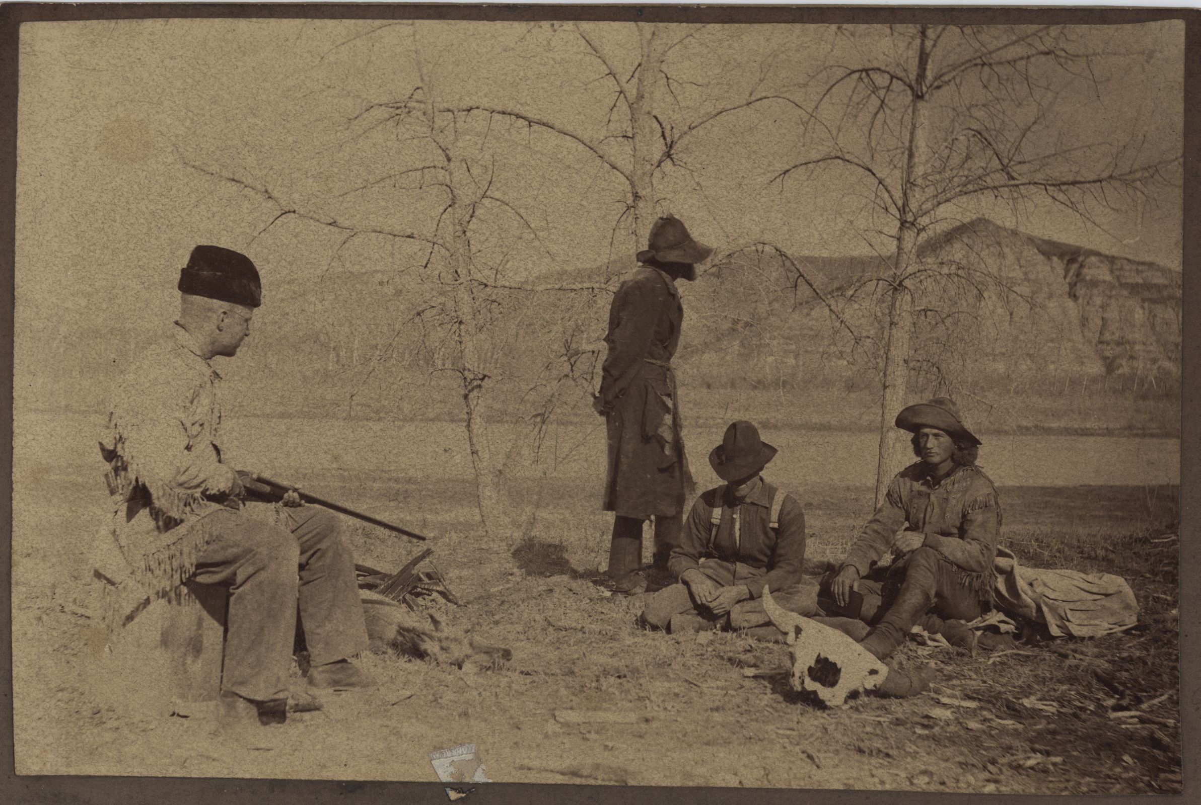 Photograph of a re-enactment of Theodore Roosevelt keeping watch over boat thieves he captured with the help of William Wingate Sewall and Wilmot Dow.