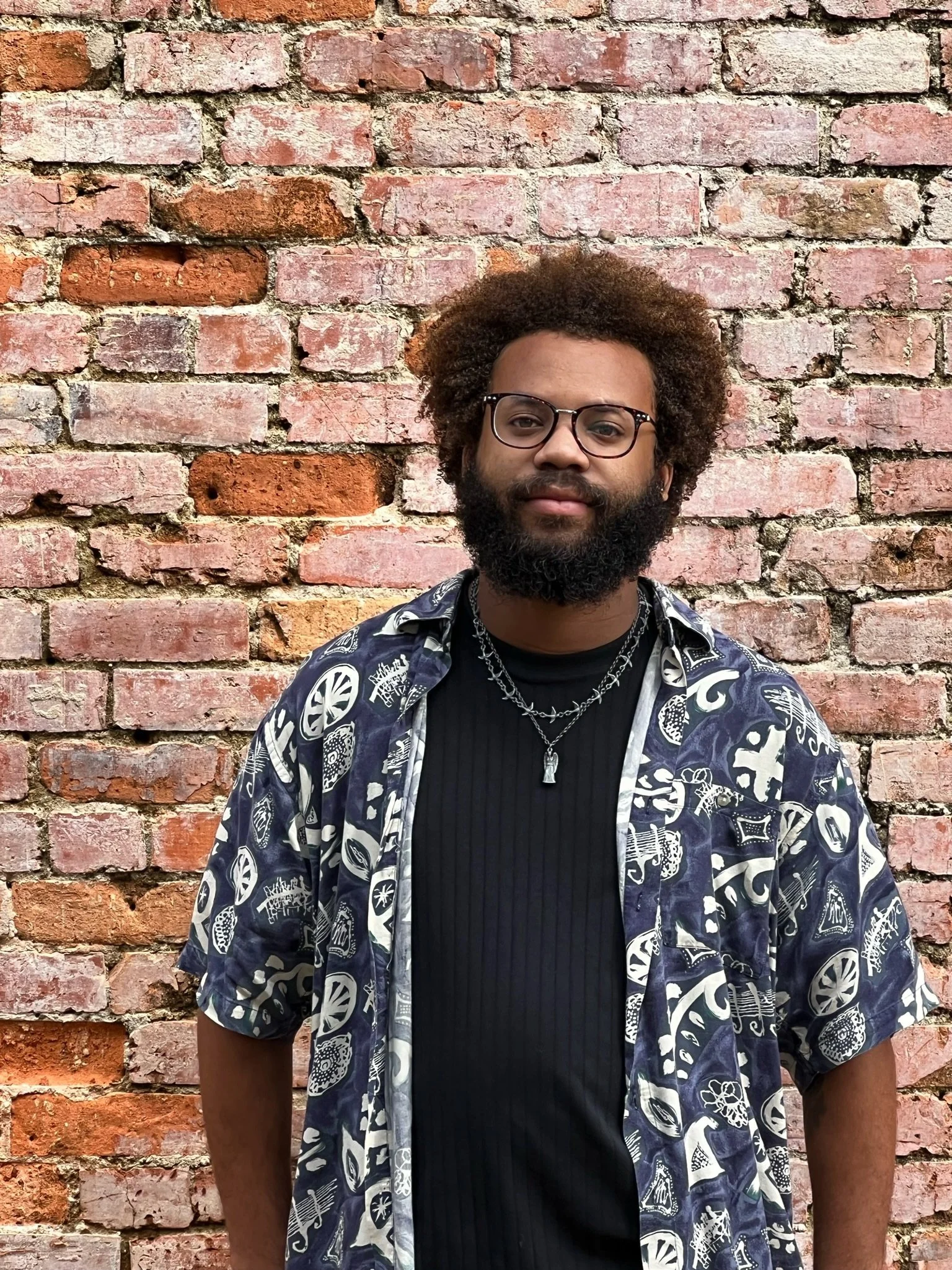 Headshot of Kenjee Roker, with a calm, neutral expression.