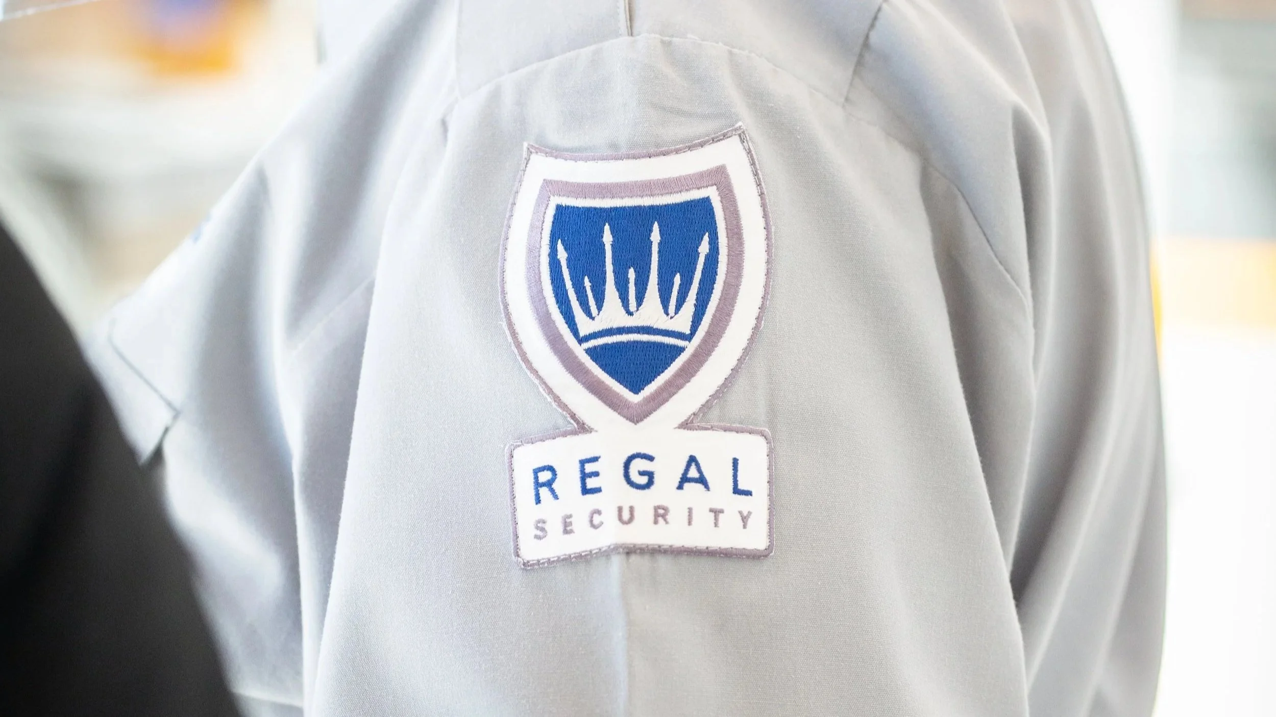 A Regal Security Guard in a uniform shirt on duty.