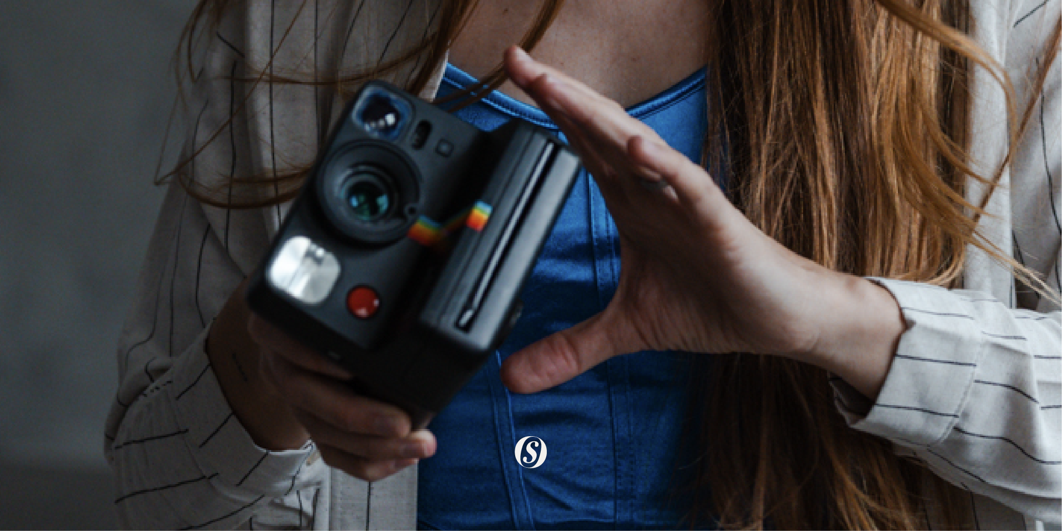 closeup of woman holding a black polaroid camera