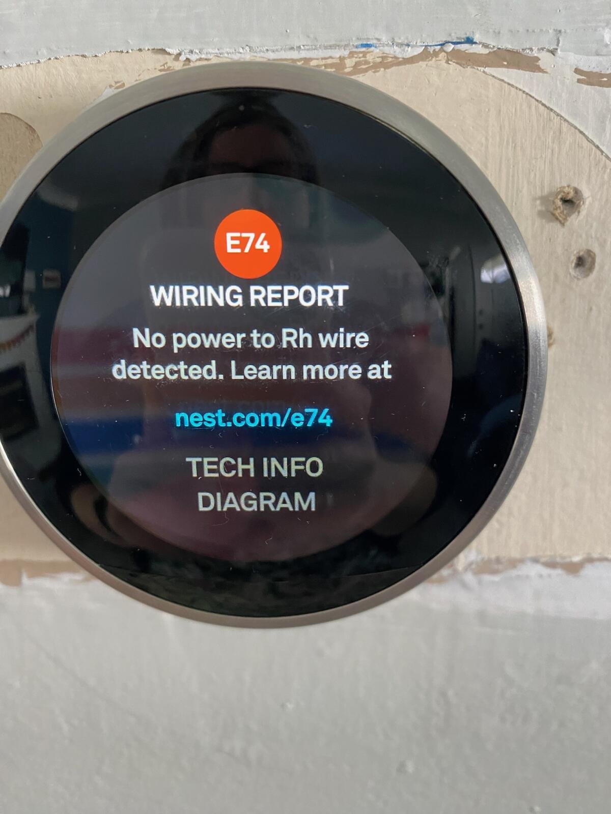 Smart thermostat displays wiring report indicating no power to the Rh wire, with a warning code E74 and a URL for more information.