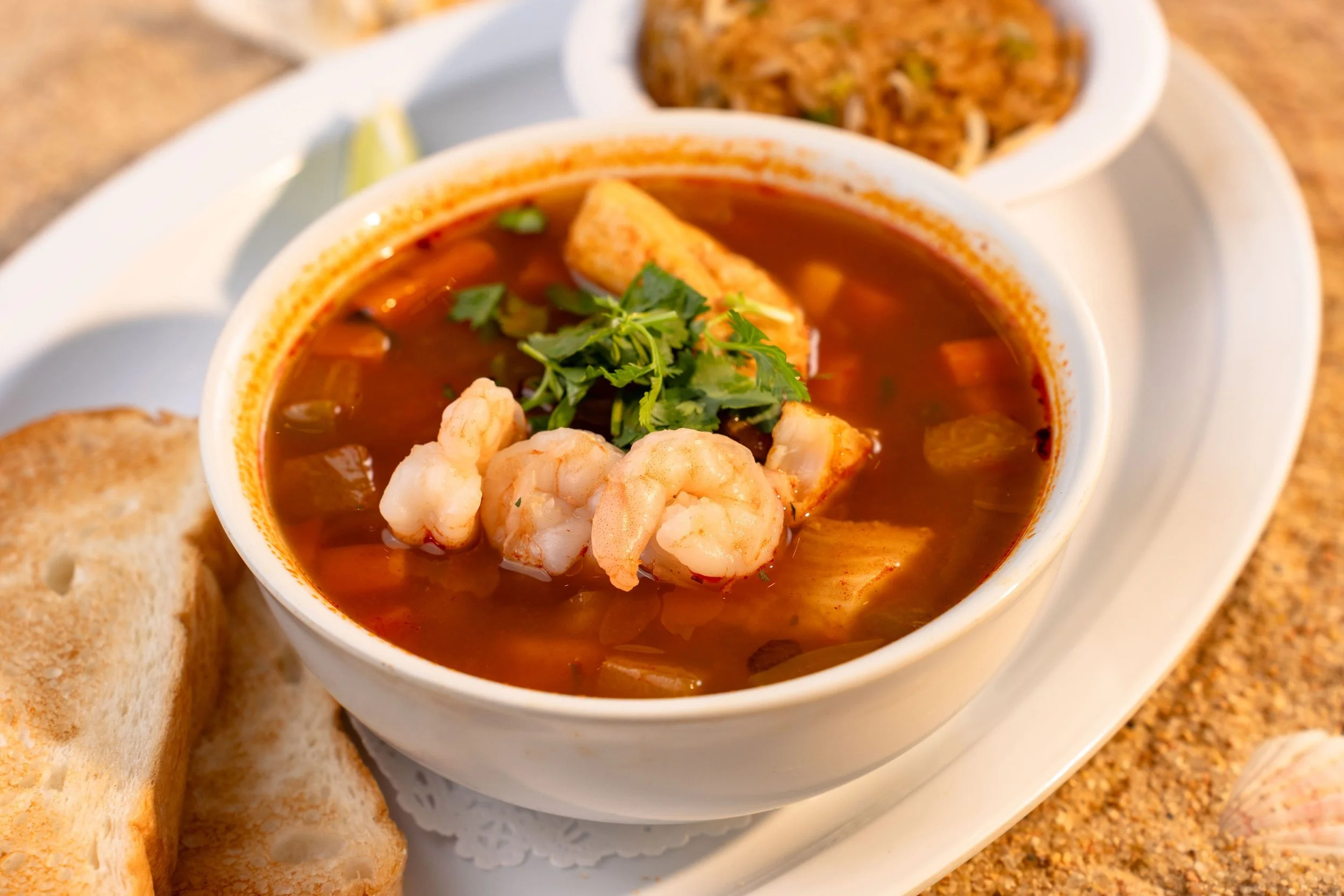 Homemade soup served with shrimp, vegetables mix, and cilantro. With two sides.