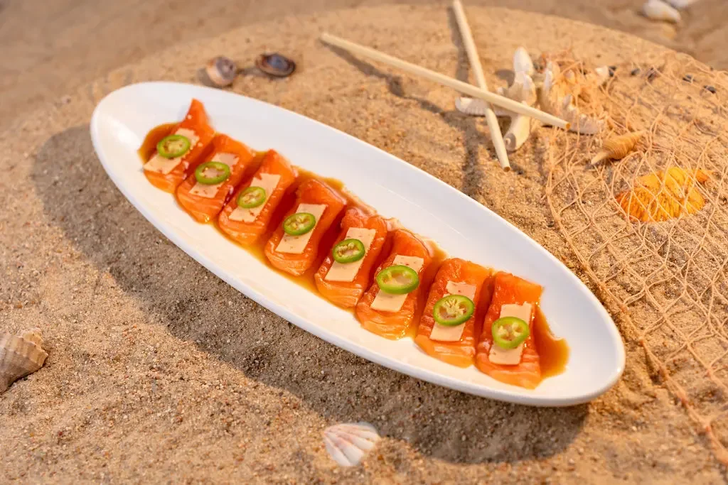 Salmon tiradito at El Muelle Seafood featuring fresh salmon, house sauce and jalapeño slices.