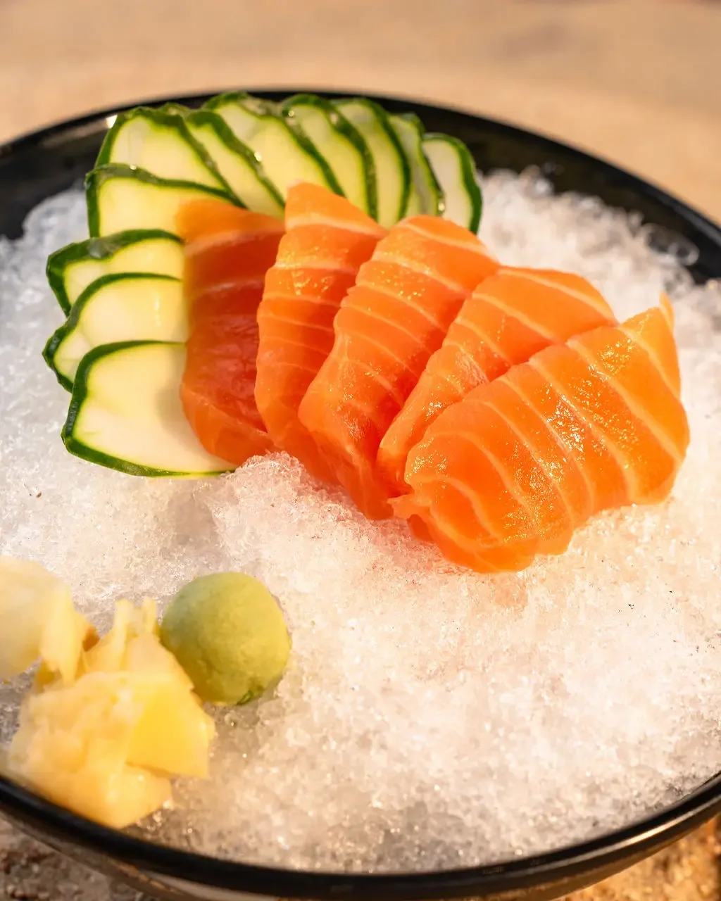 Salmon sashimi served over ice with cucumber, wasabi and pickled ginger at El Muelle Seafood in Houston
