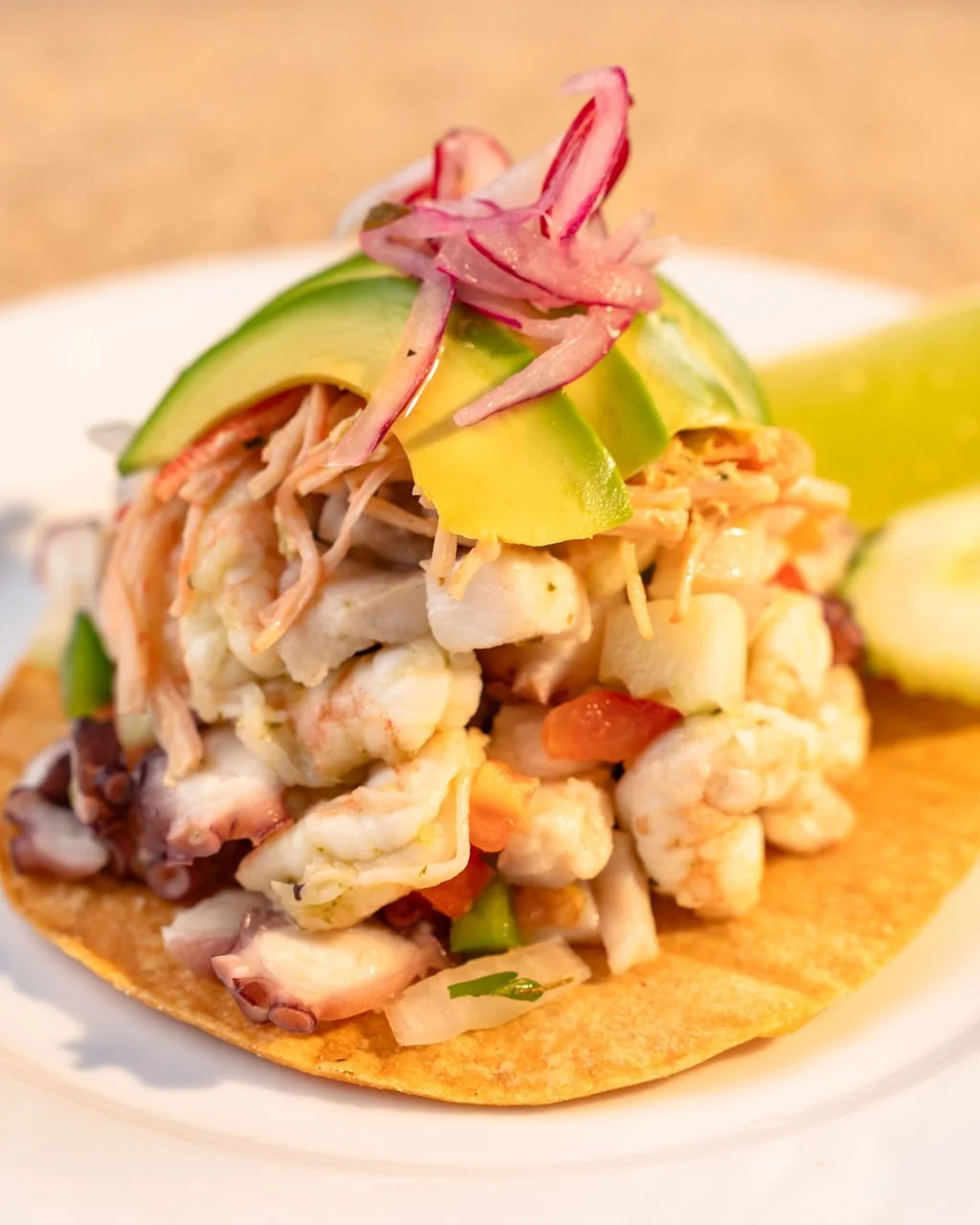 Signature Torre de Mariscos at El Muelle Seafood made with shrimp, octopus, fresh seafood, avocado and house-made coastal flavors.