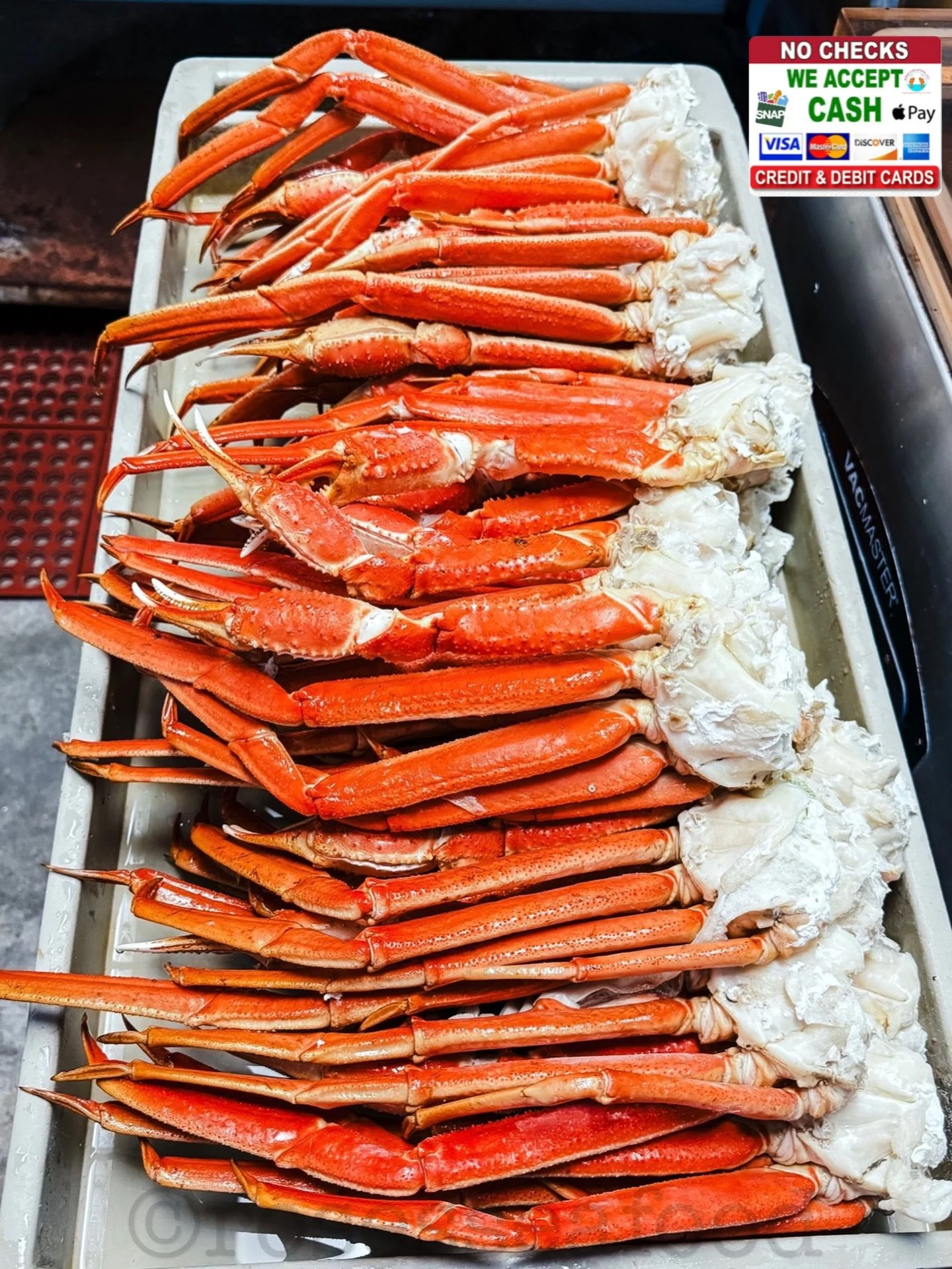 Row of crab legs on ice in metal tray