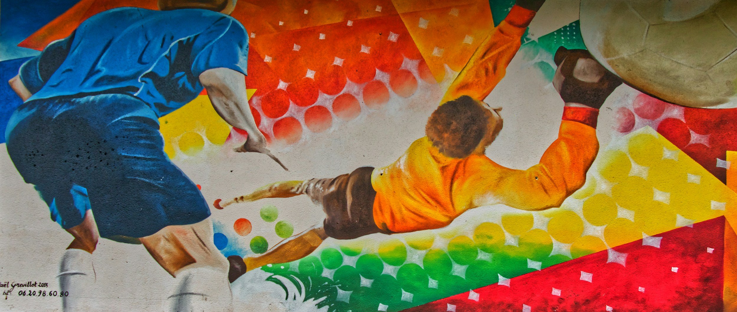 Colorful image of young man sliding to hit a soccer ball with his hand