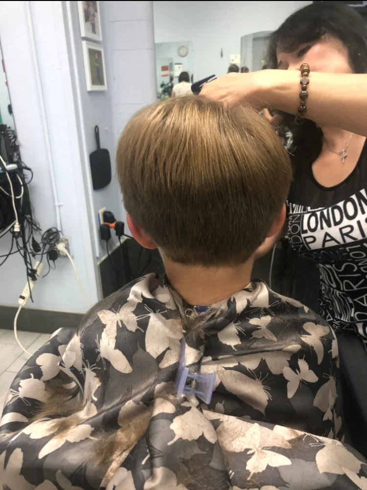Woman cutting hair of child