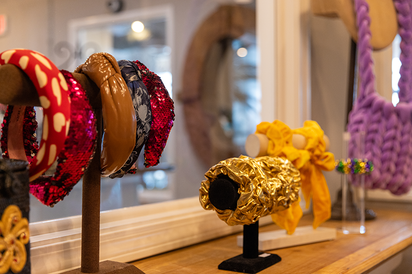Wooden stand with colorful bracelets and headbands hanging from it