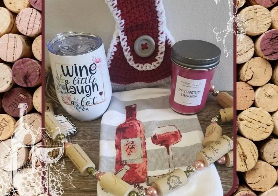 Wine themed tumbler next to a pink candle and towel with wine bottle and glass