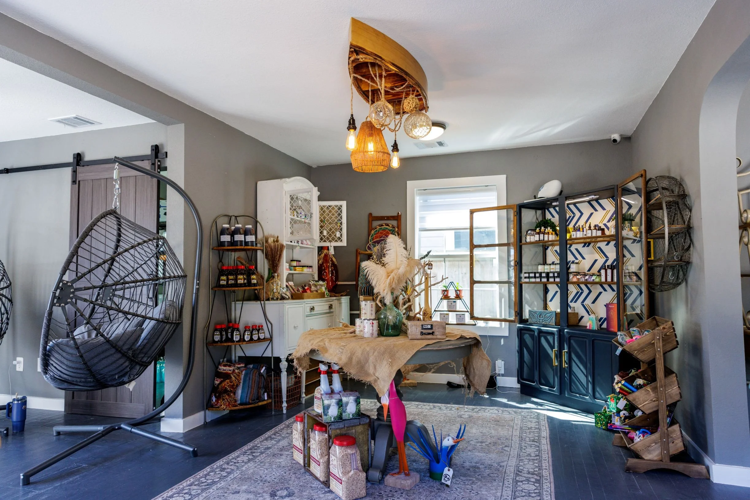 Coffee shop interior with table covered in burlap with a vase of floors and canoe light fixture on ceiling