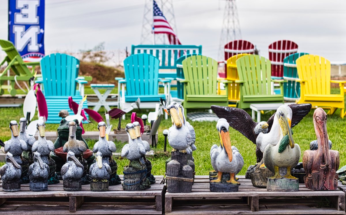 Pelican statues in front of colorful Adirondack chairs