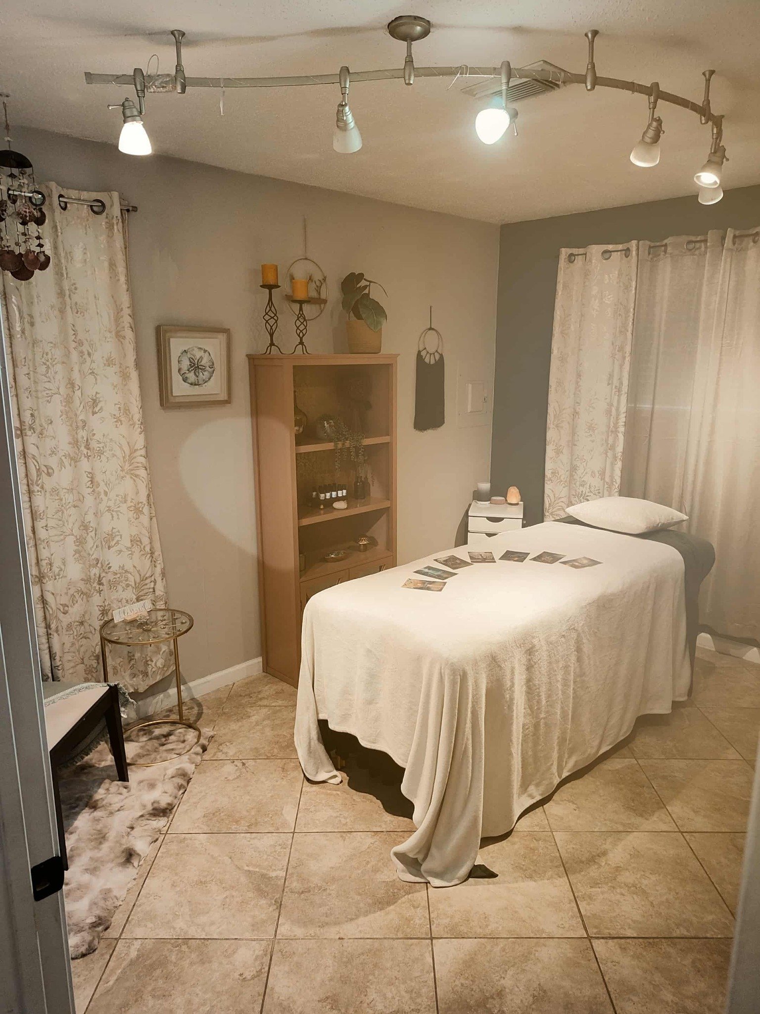 Massage room bed with pillow and blanket and wood bookcase