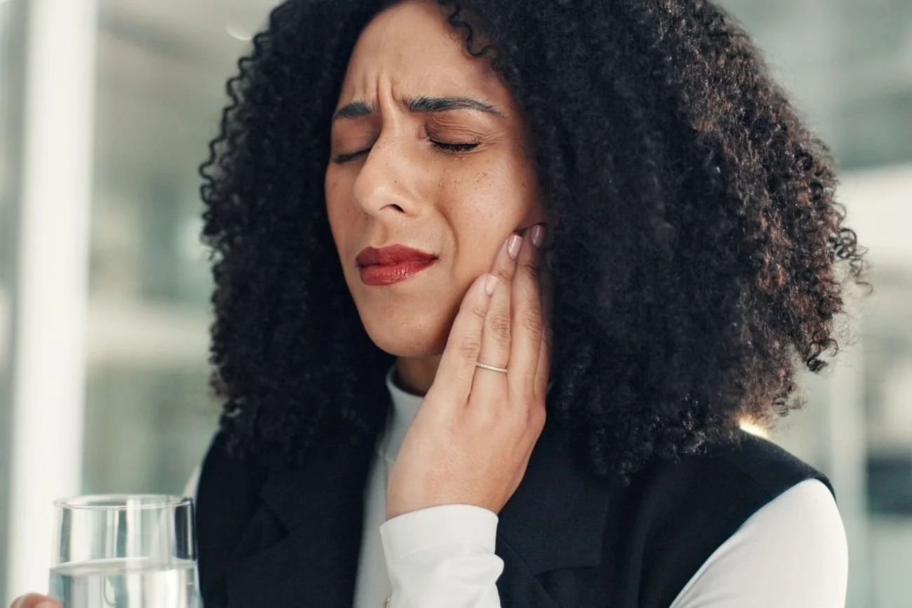 person holding jaw in tmj pain