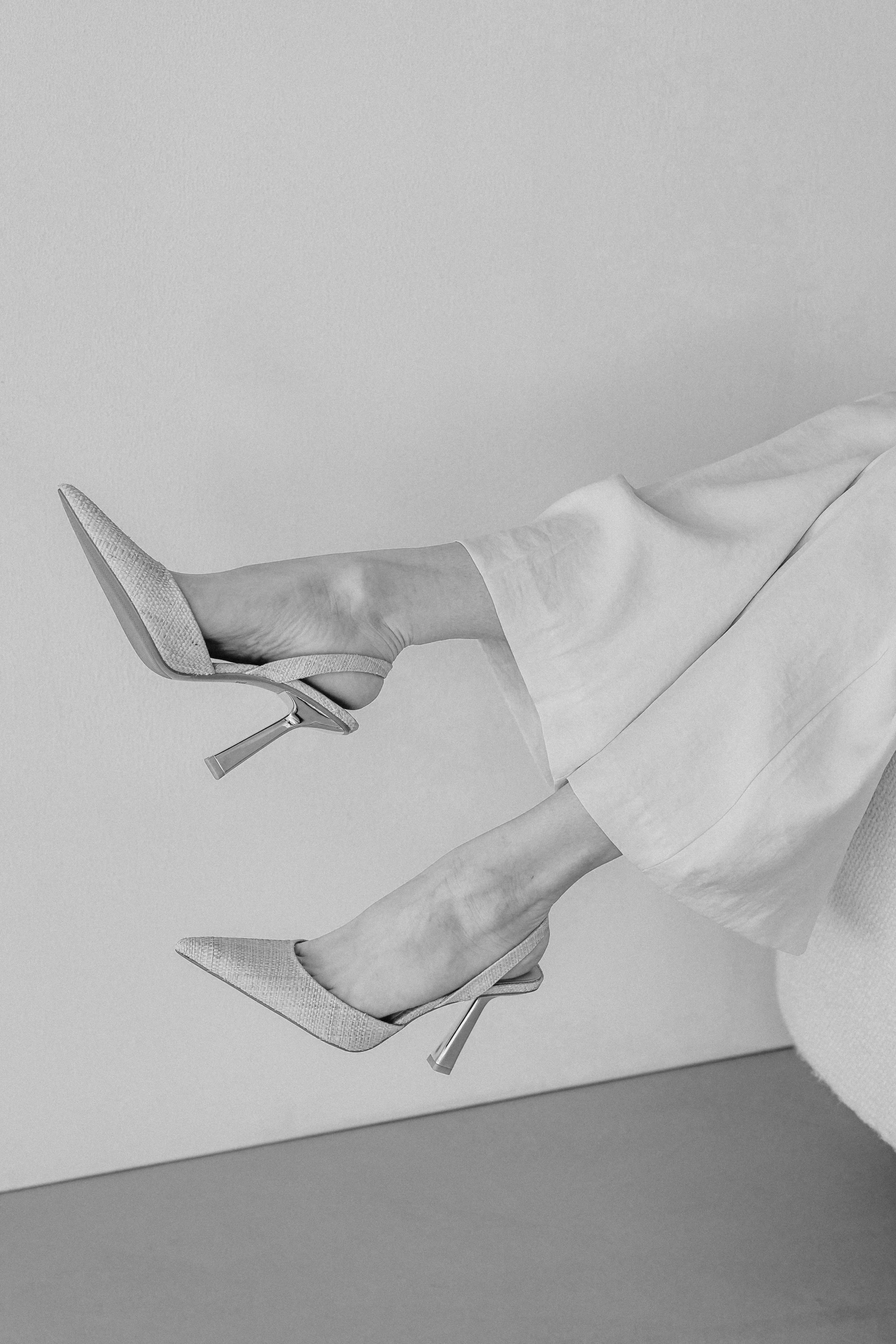 Career woman wearing high heels and kicking her feet off a chair.