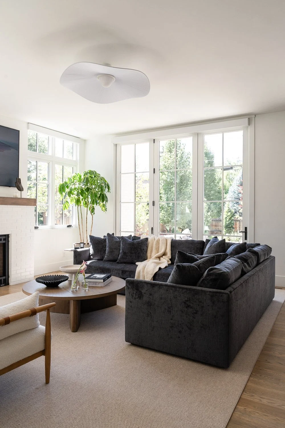 Studio Thomas Denver bespoke interior design no 035 great room dark upholstered sectional paneled windows light wood coffee table