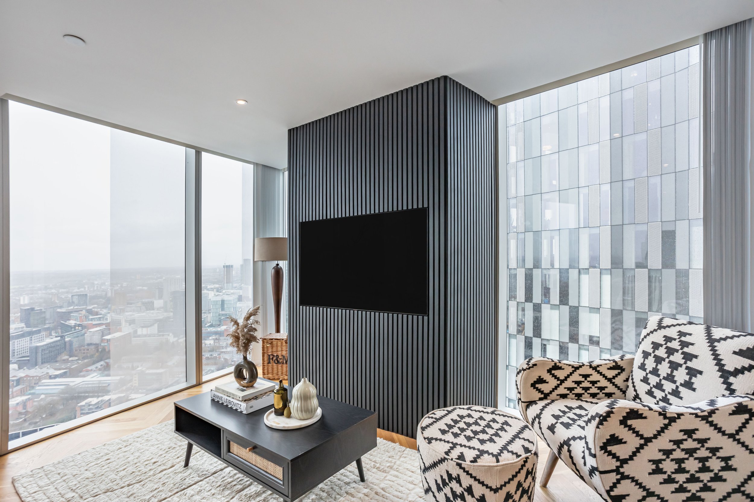 A black TV media wall with a view of Manchester