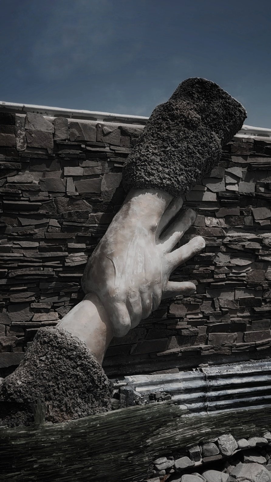 Sculpture of hands at war memorial.