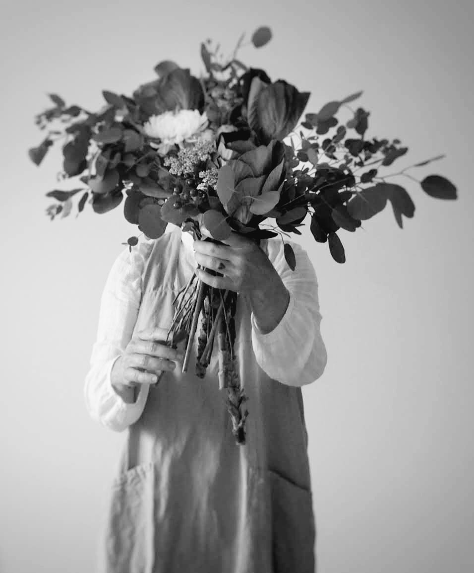 Self portrait holding floral arrangement.