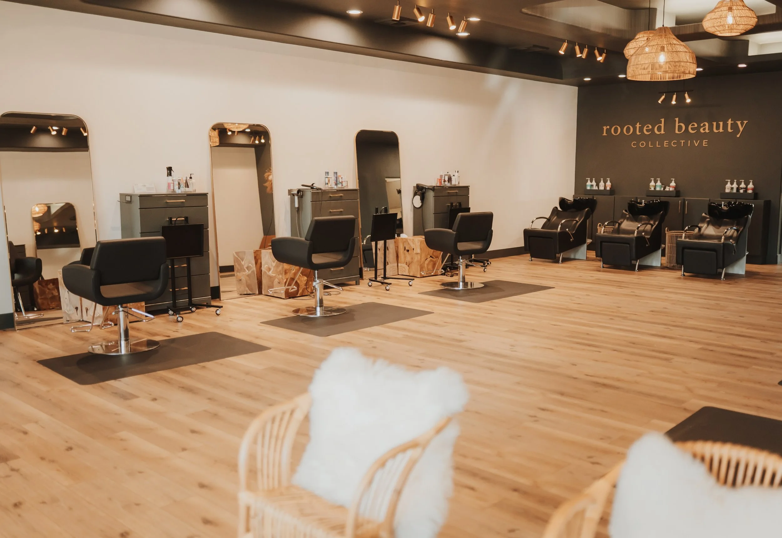 Interior of a modern hair salon with styling chairs, mirrors, and washing stations.
