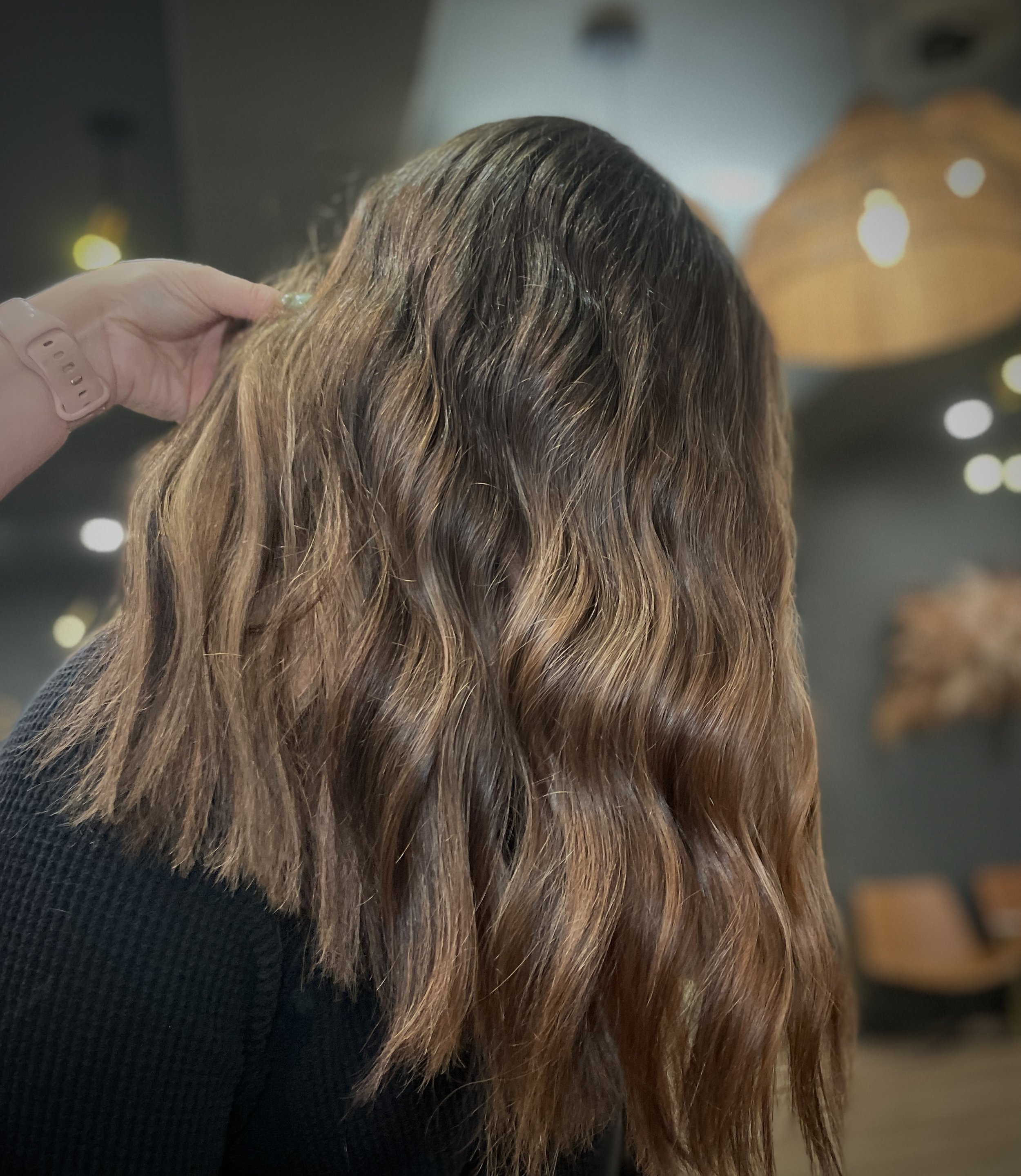 Person with wavy brown hair indoors