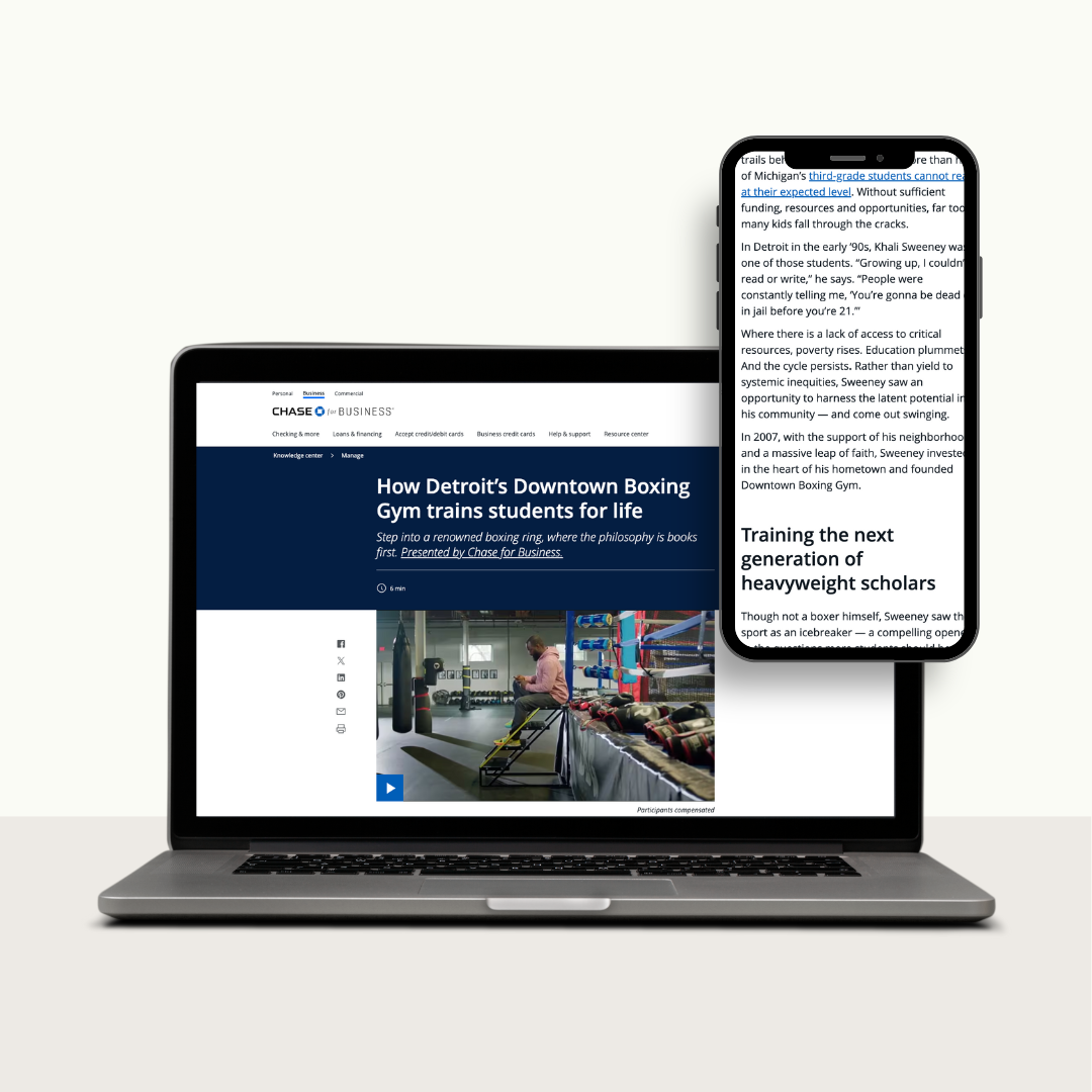 A laptop with a webpage open about Detroit's downtown boxing gym and a smartphone displaying text related to educational topics.