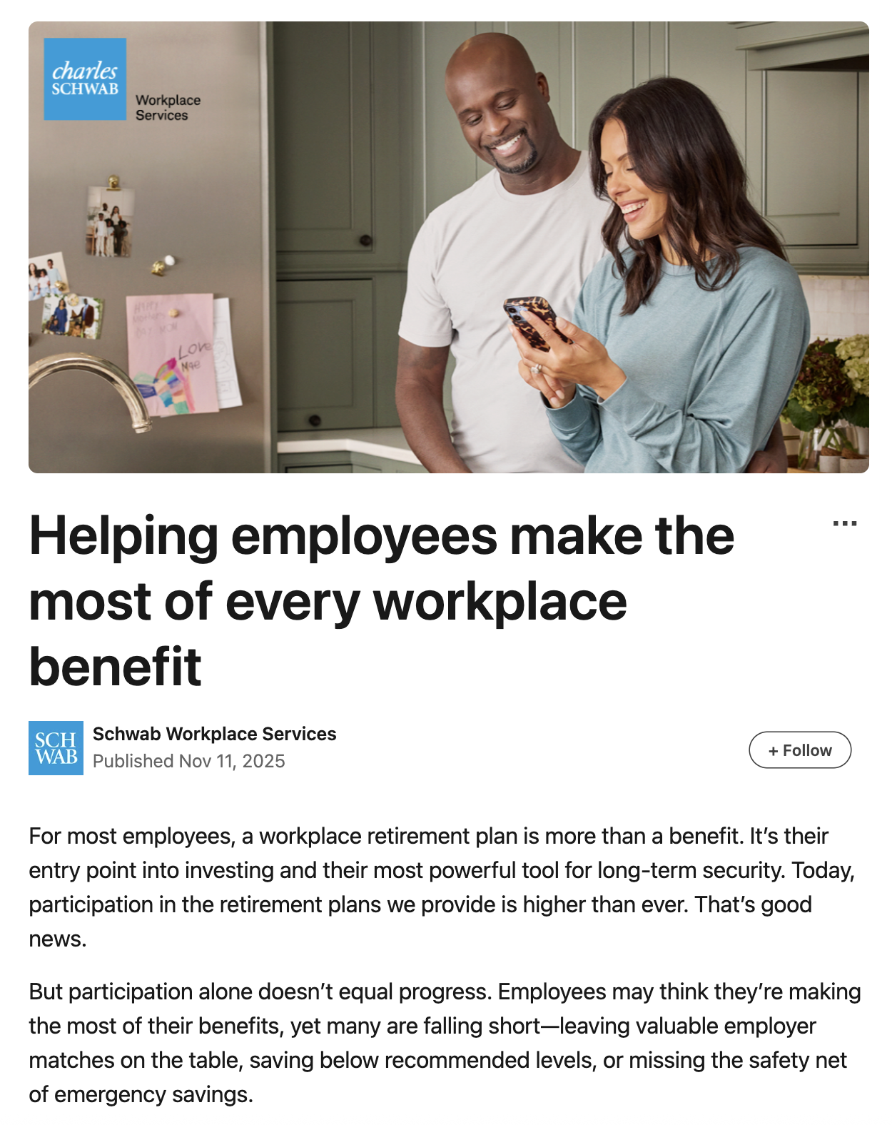 Two employees, a man and a woman, standing in a kitchen, looking at a phone and smiling.