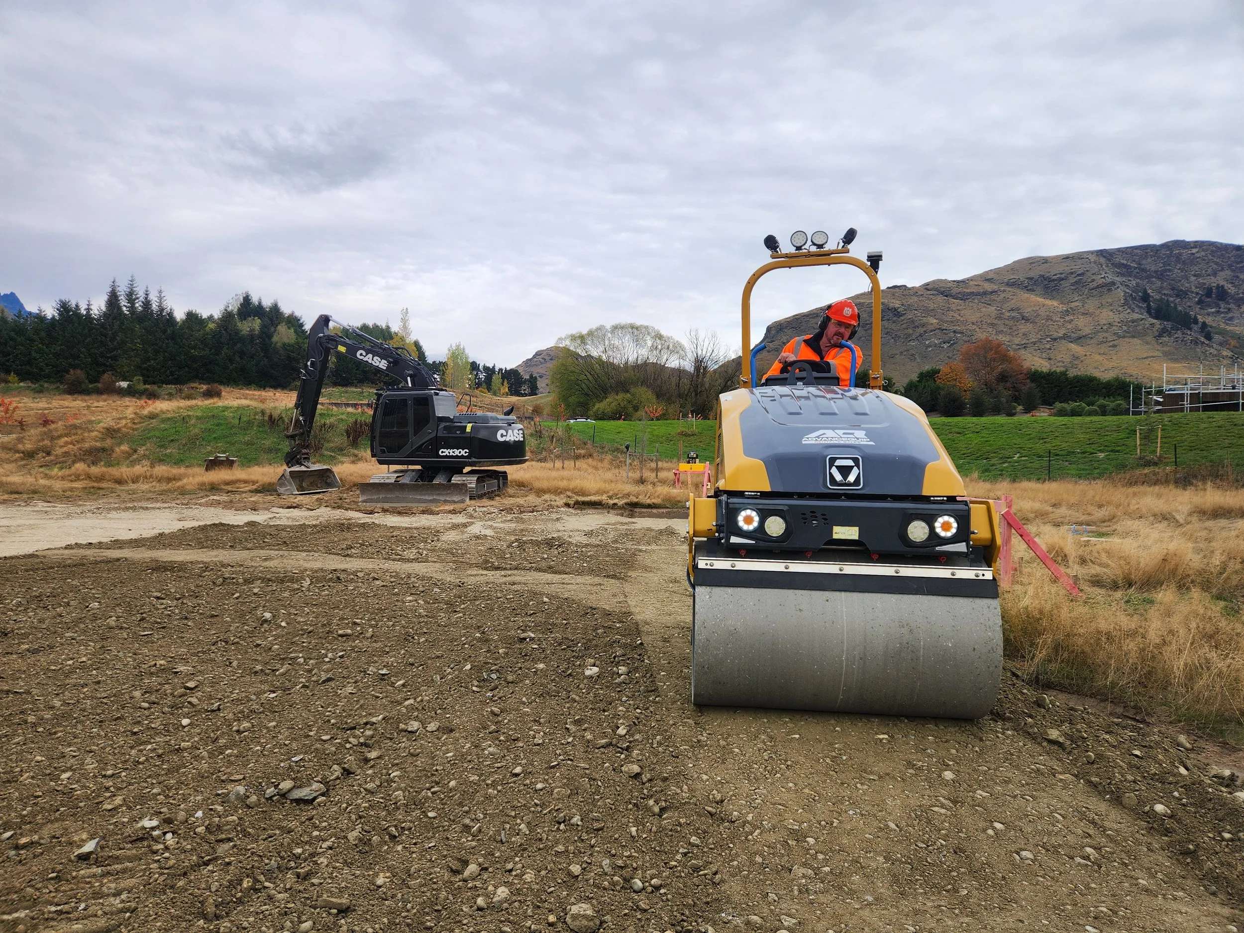 smooth drum roller compacting metal on a building platform