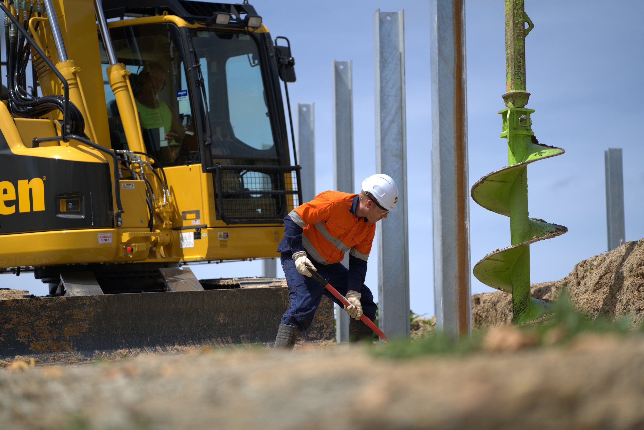 excavator and site worker drilling pile holes in auckland