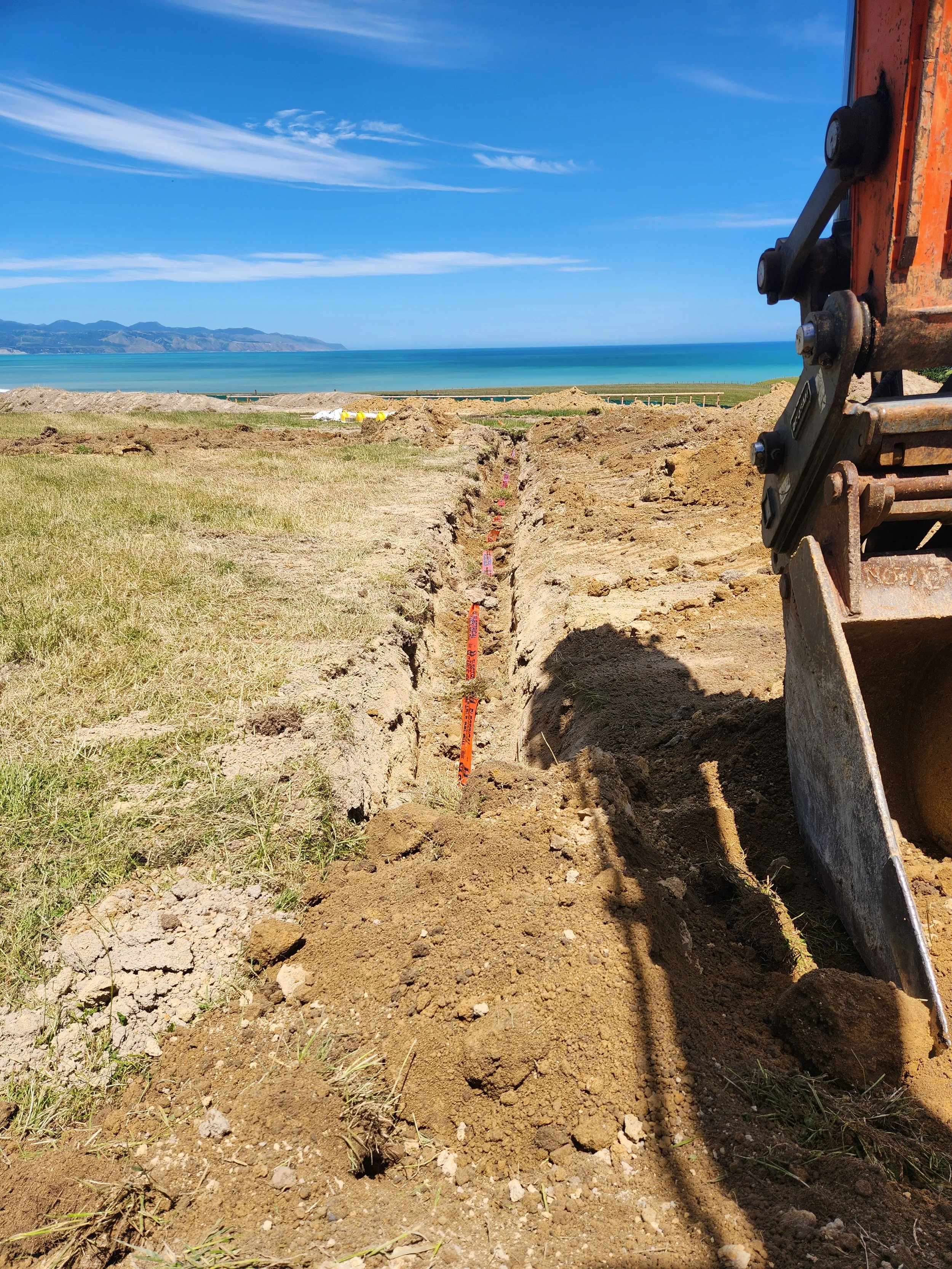 an excavator digging a trench for an electrical mains cable on a lifestyle property
