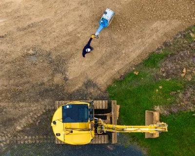 worker compacting metal for accessway on Auckland residential earthworks site run by Oxen limited