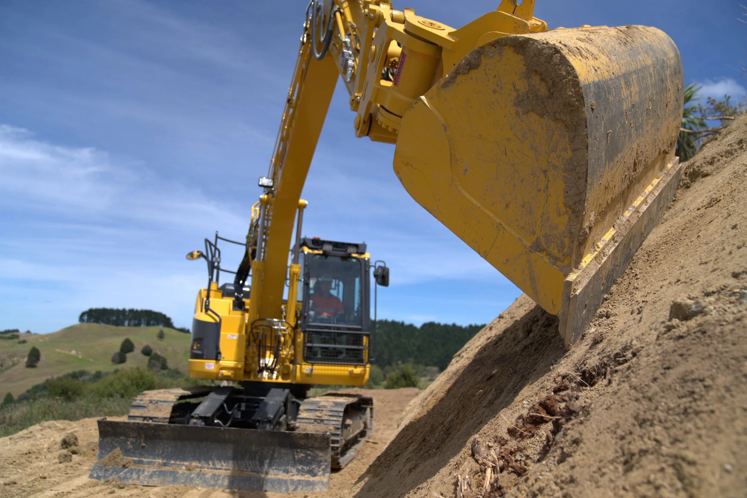 Excavator doing a clay batter cut on a residential site in Auckland