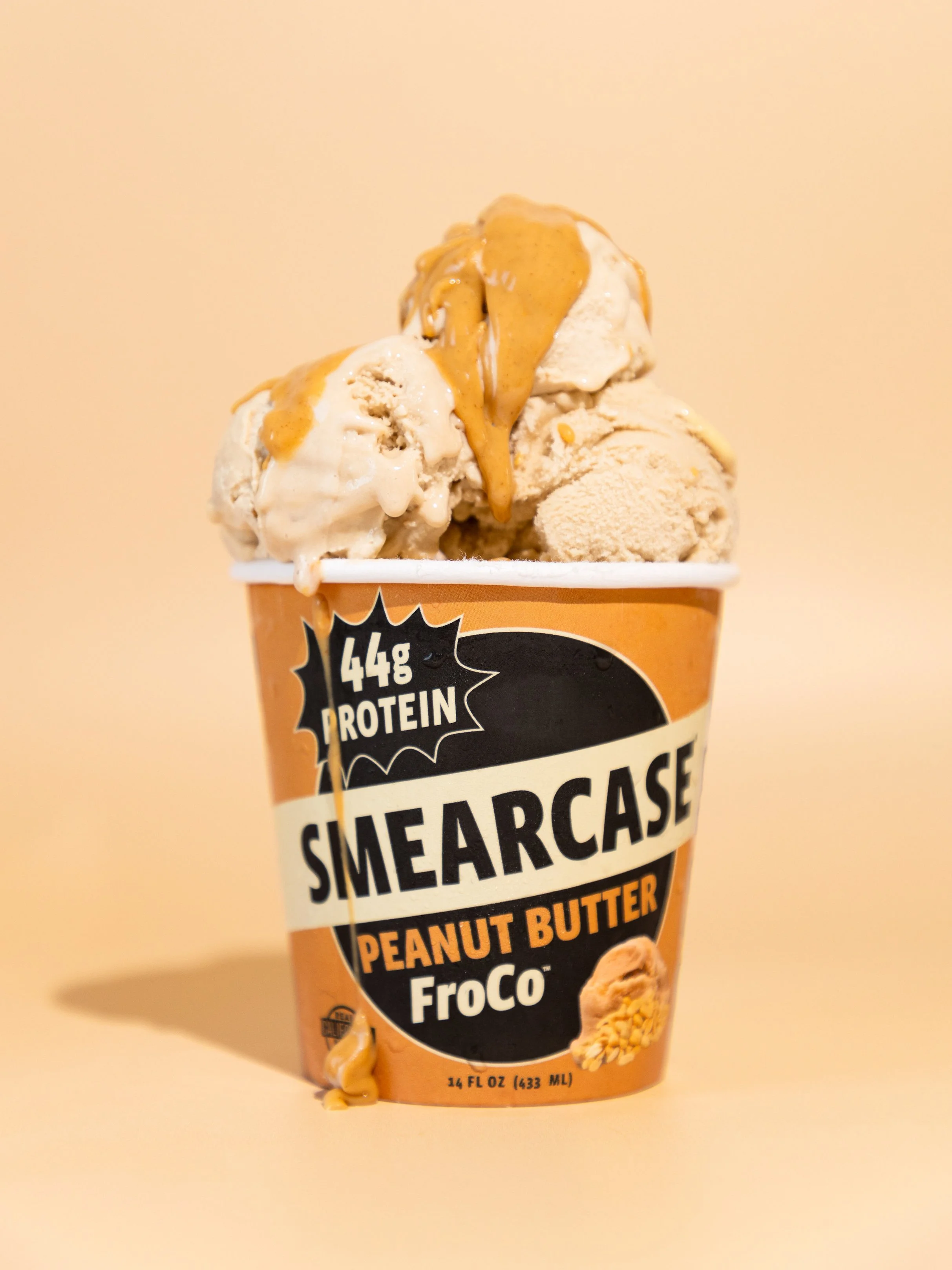 Container of Smearcase FroCo peanut butter ice cream with three scoops and peanut butter drizzle. Commercial product photography for CPG, food, and beverage brands, creating e-commerce, social media, and marketing-ready product images. 