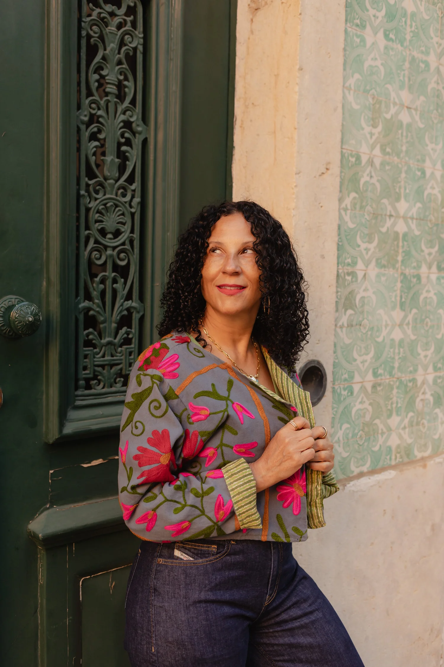 Dr. Cara Alexander standing by a green doorway, smiling