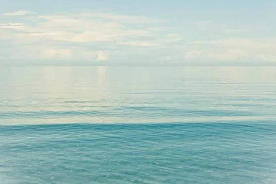Calm ocean with gentle waves under partly cloudy sky