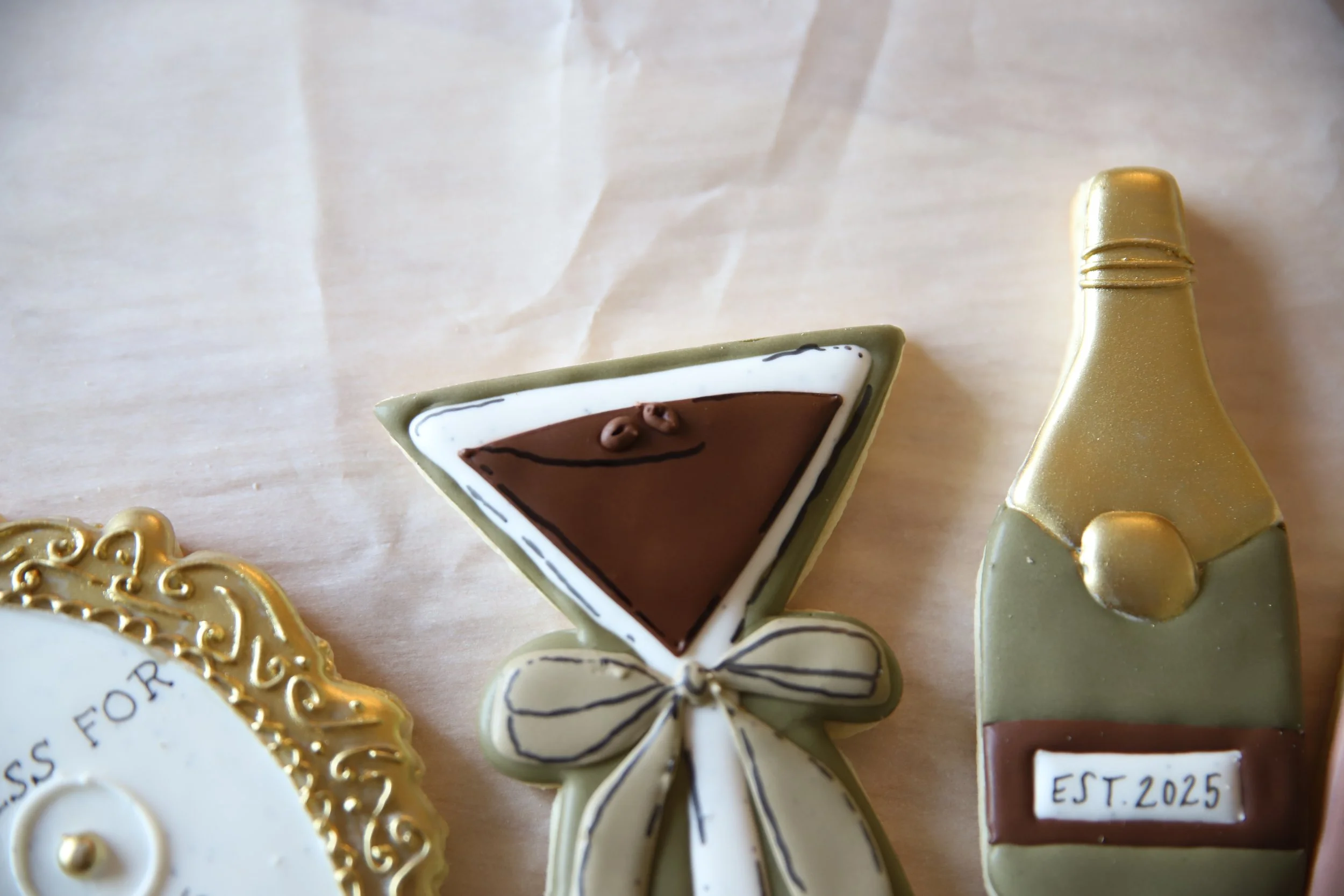 Decorative edible cookies and confections with gold accents and a martini glass shape.