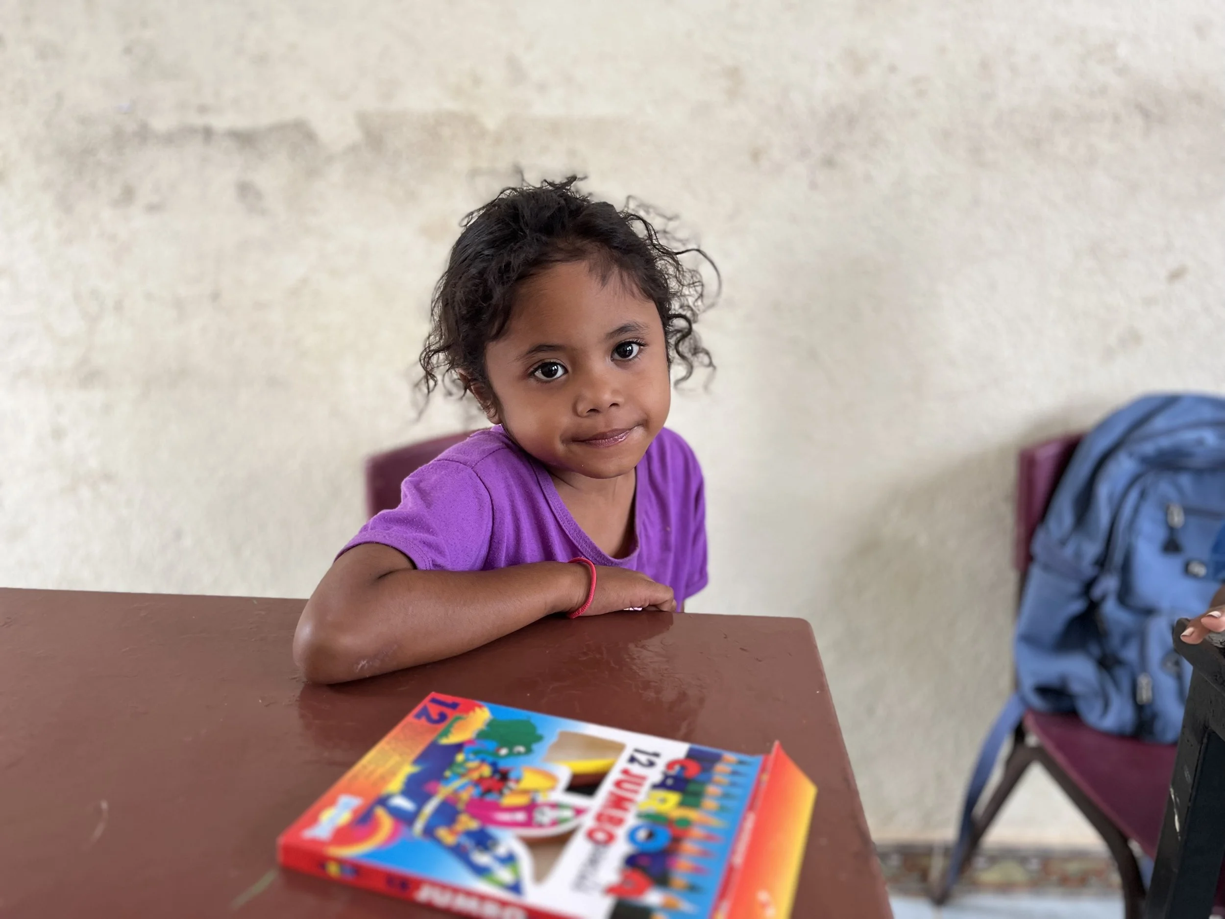 Young girl poses shyly as she awaits teacher instruction