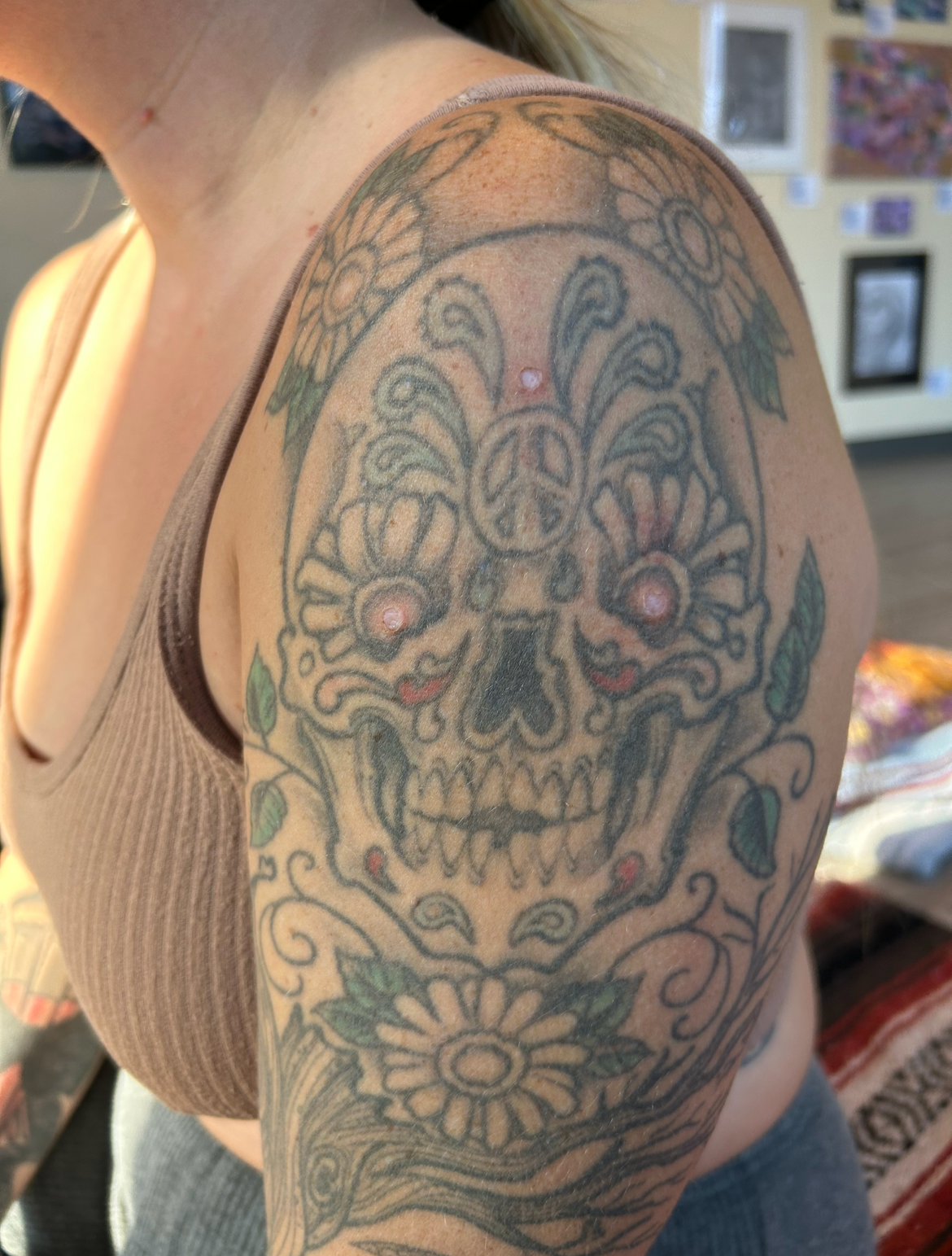 A close-up of a participant’s shoulder showing fresh Kambo points over a colorful tattoo during ceremony at Ahavah Gardens, highlighting healing, tradition, and sacred practice.